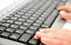 Hands typing on a computer keyboard